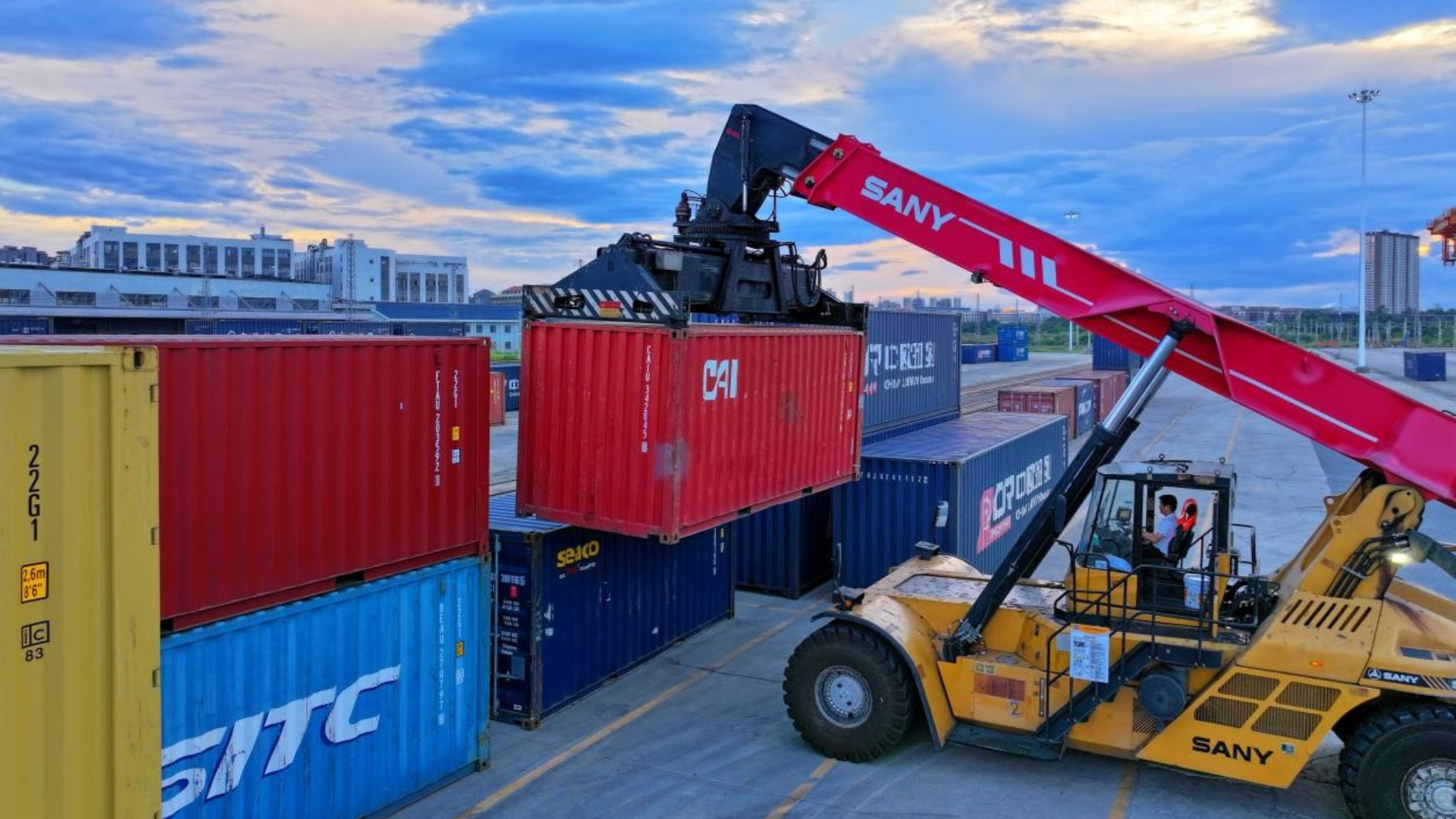 A panoramic aerial view of the bustling Ningbo-Zhoushan Port, showing thousands of stacked containers and large cargo ships at the docks.