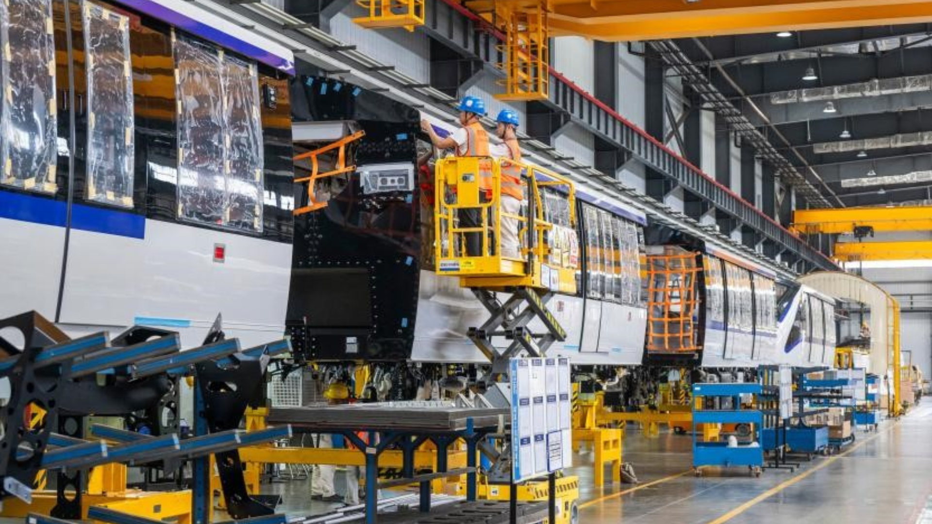 Skilled technicians and industrial robots working together in a high-tech manufacturing workshop at CRRC Puzhen Alstom in Wuhu, China.