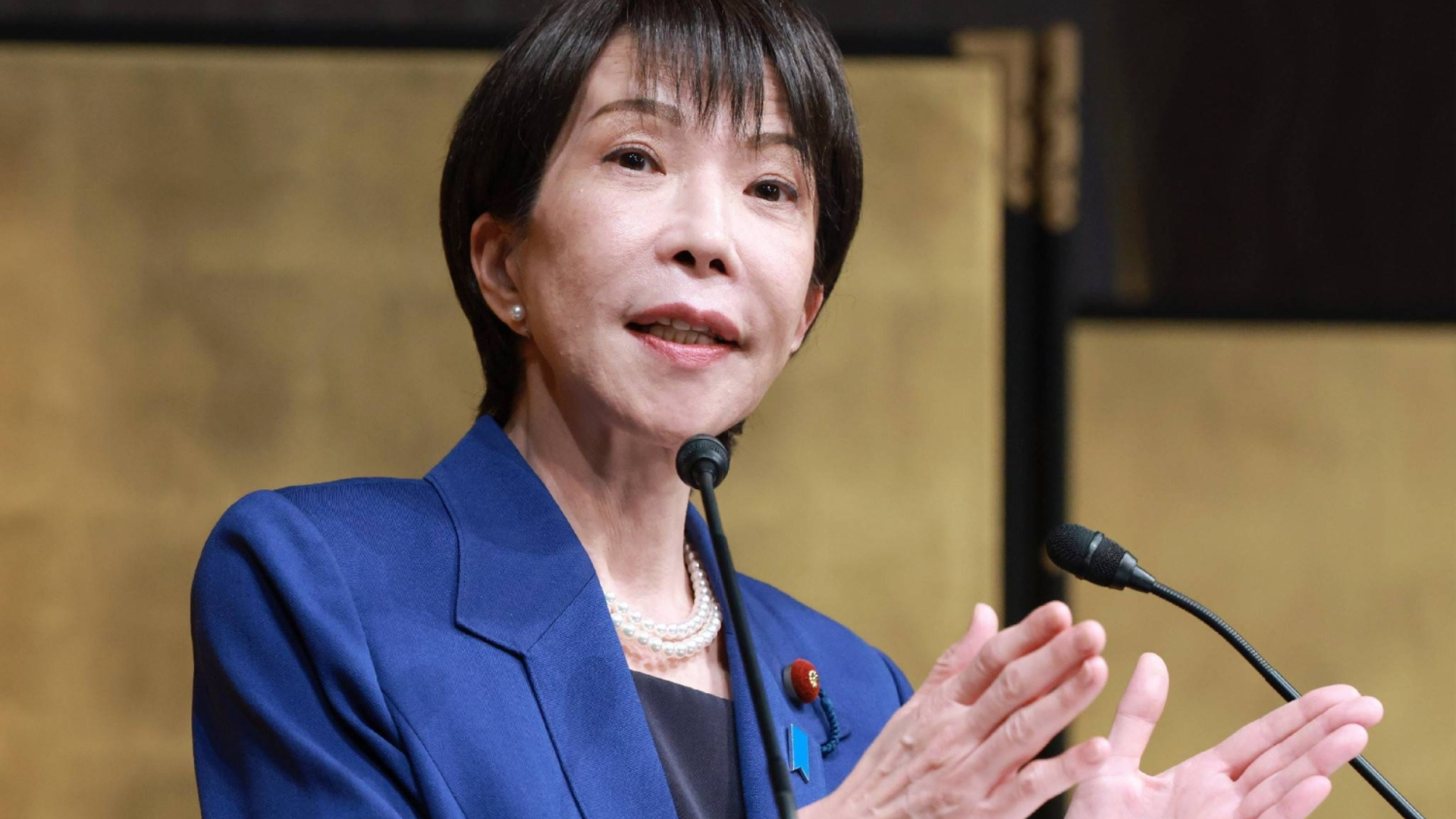 Japanese Prime Minister Sanae Takaichi gestures while speaking about Japan's record-high 9.04 trillion yen defense budget.