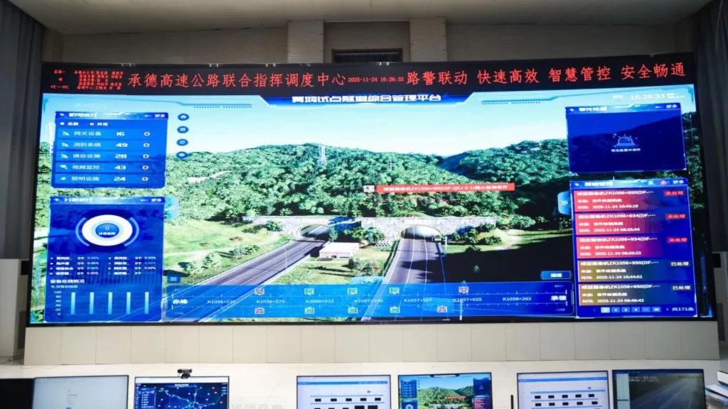An engineer monitors a smart tunnel system using the OpenHarmony-based "JiHong" solution on a screen.