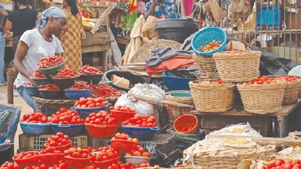 Crowded Lagos market shoppers facing high inflation, buying smaller food portions for a lean Christmas.