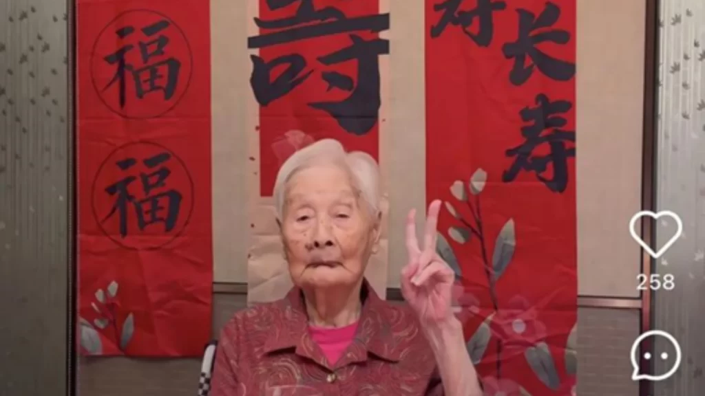 Centenarian Zhong Wenyu enjoys milk tea and tablet games while basking in the afternoon sun.