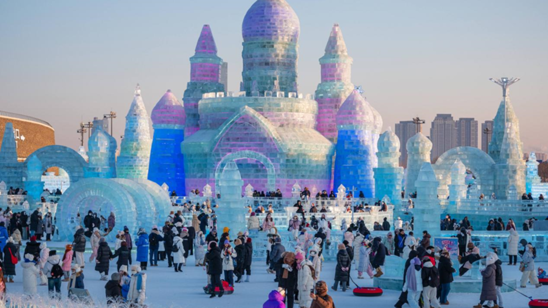 Vibrant ice sculptures glow at night in Harbin's Ice and Snow World, attracting massive crowds.