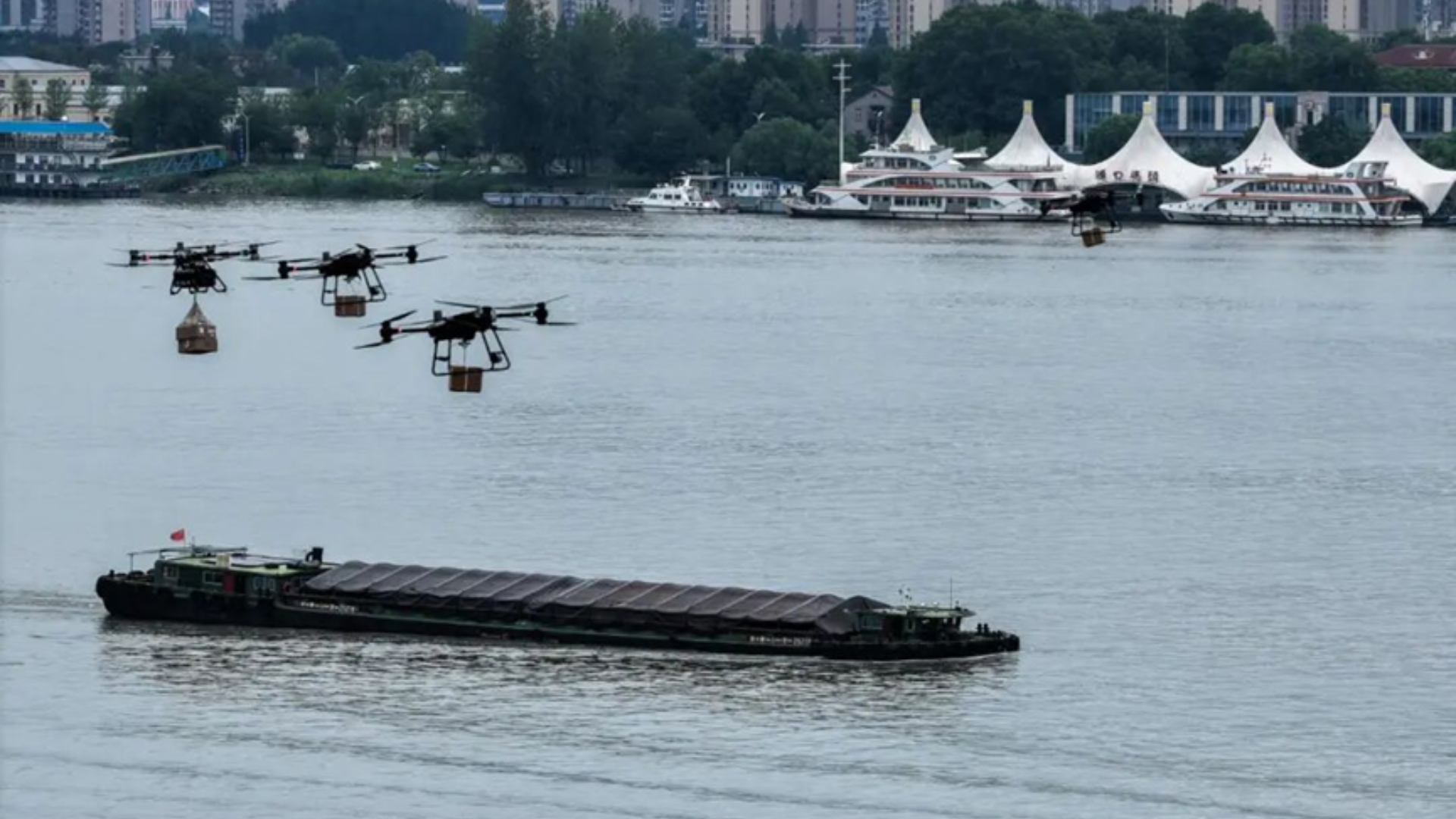Drone delivering food to a moving cargo ship on the Yangtze River via autonomous cable.