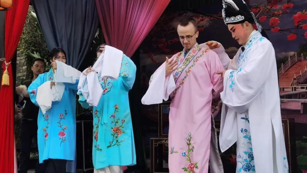 精准捕捉了活动的重点与核心要素： 中外友人在海口体验剪纸、书法等非遗文化，共庆马年新春。