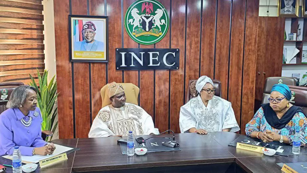 INEC officials seated at a conference table, symbolizing the postponed nationwide voter revalidation exercise.