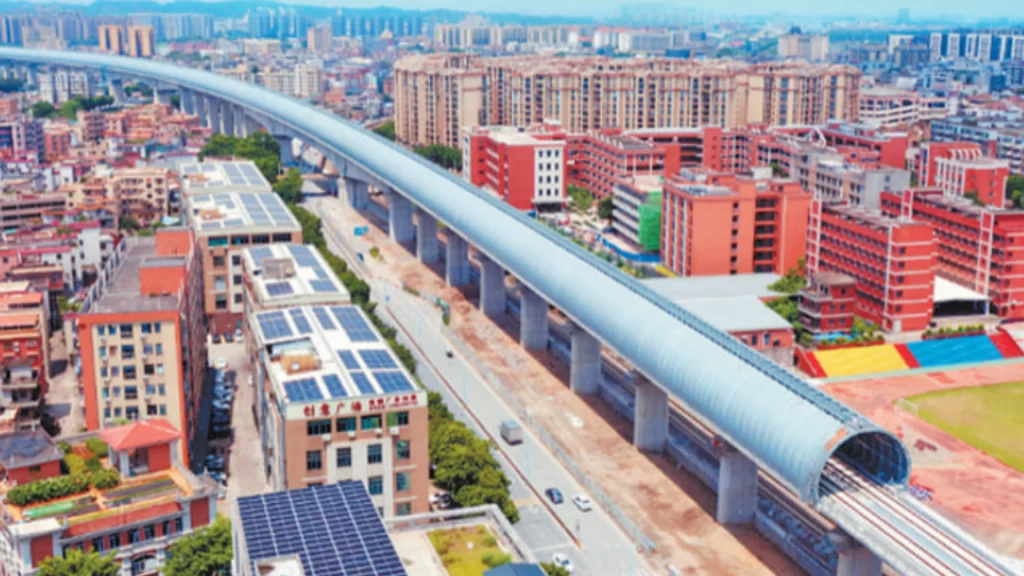 Aerial view of a high-speed railway enclosed in a fully soundproof tunnel through a city.
