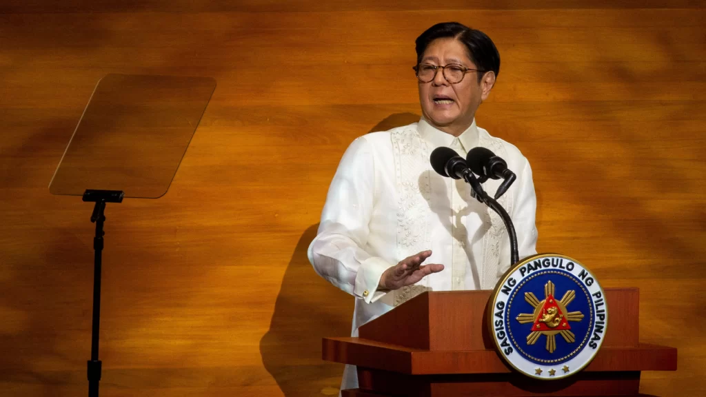 President Ferdinand Marcos Jr. delivering a speech at a podium with the Philippine presidential seal.