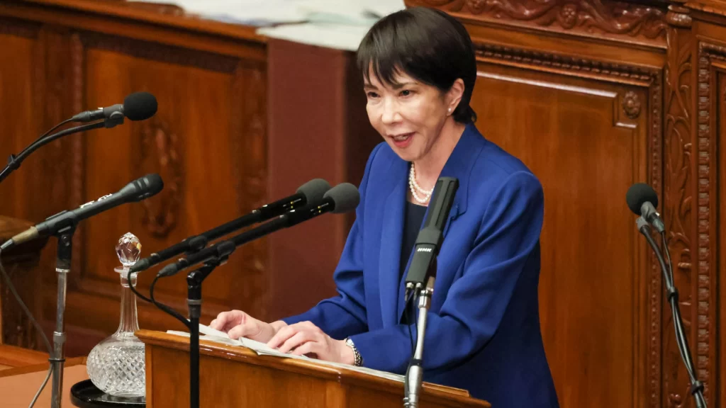Japanese Prime Minister Sanae Takaichi delivers a speech, symbolizing the country's controversial shift toward offensive capabilities.