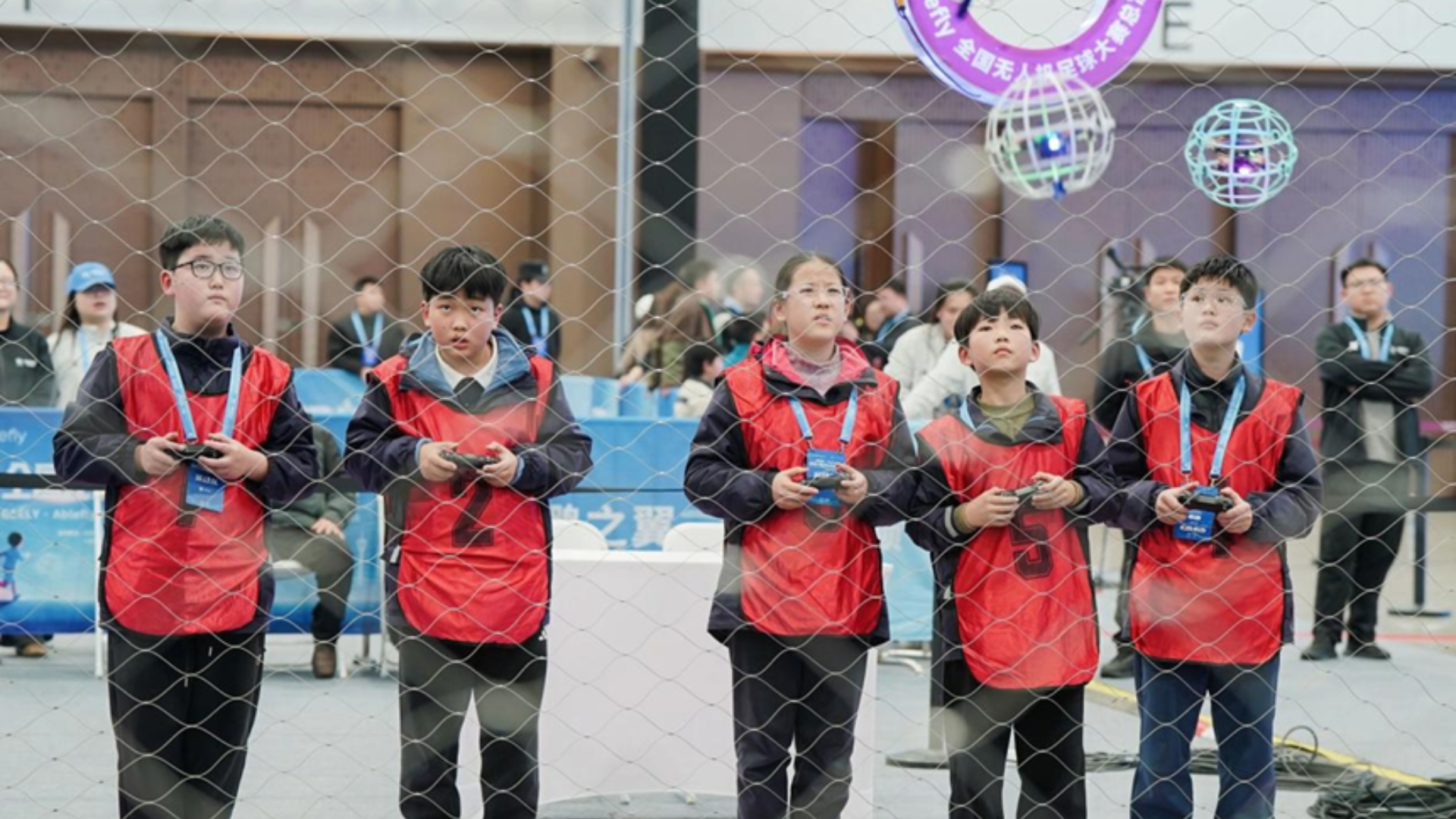 Young players use controllers to maneuver spherical drones during the Ablefly National Drone Soccer Championship.