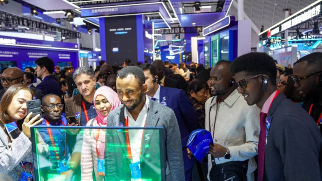 International visitors at a technology exhibition view a transparent AI display showcasing smart digital solutions.