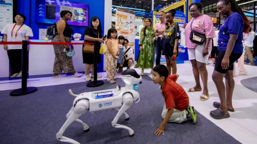 A boy interacts with a robotic dog at the China International Consumer Products Expo.