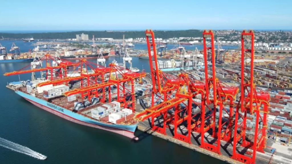 An aerial view of the Port of Durban showing red cranes loading a Maersk ship.