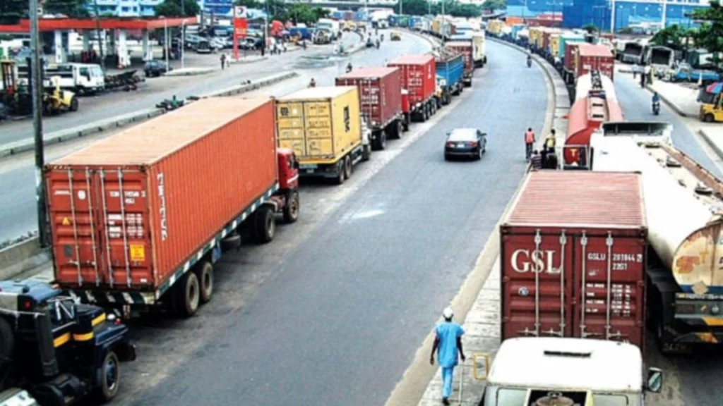 Long line of container trucks parked along a Nigerian highway amidst significant port congestion.