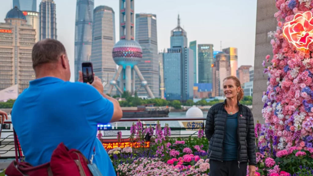 An Australian tourist smiles for a photo with Shanghai's iconic skyline during China's bustling May Day.
