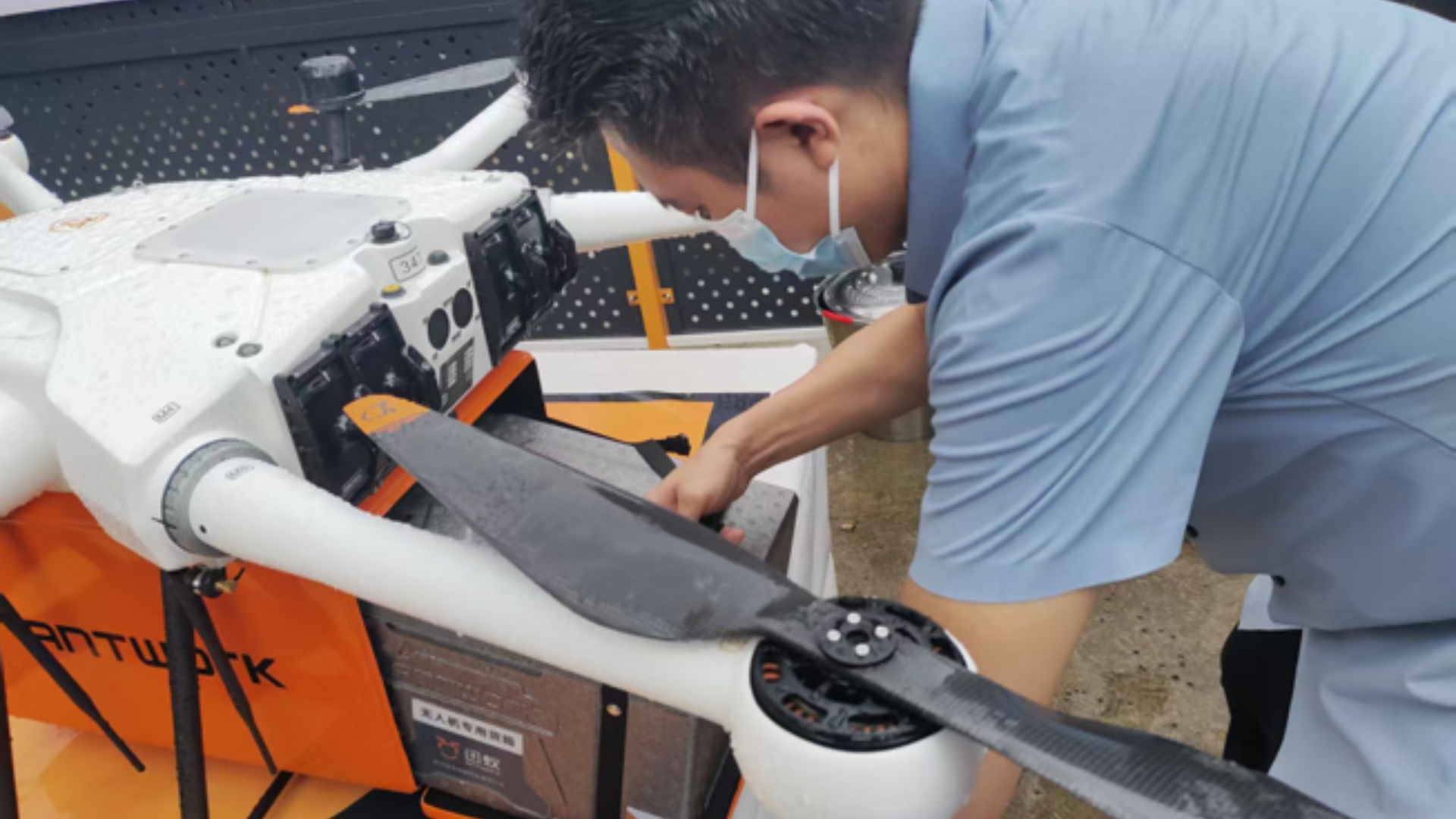 A drone technician installs a battery for a low-altitude medical logistics flight in Hainan.