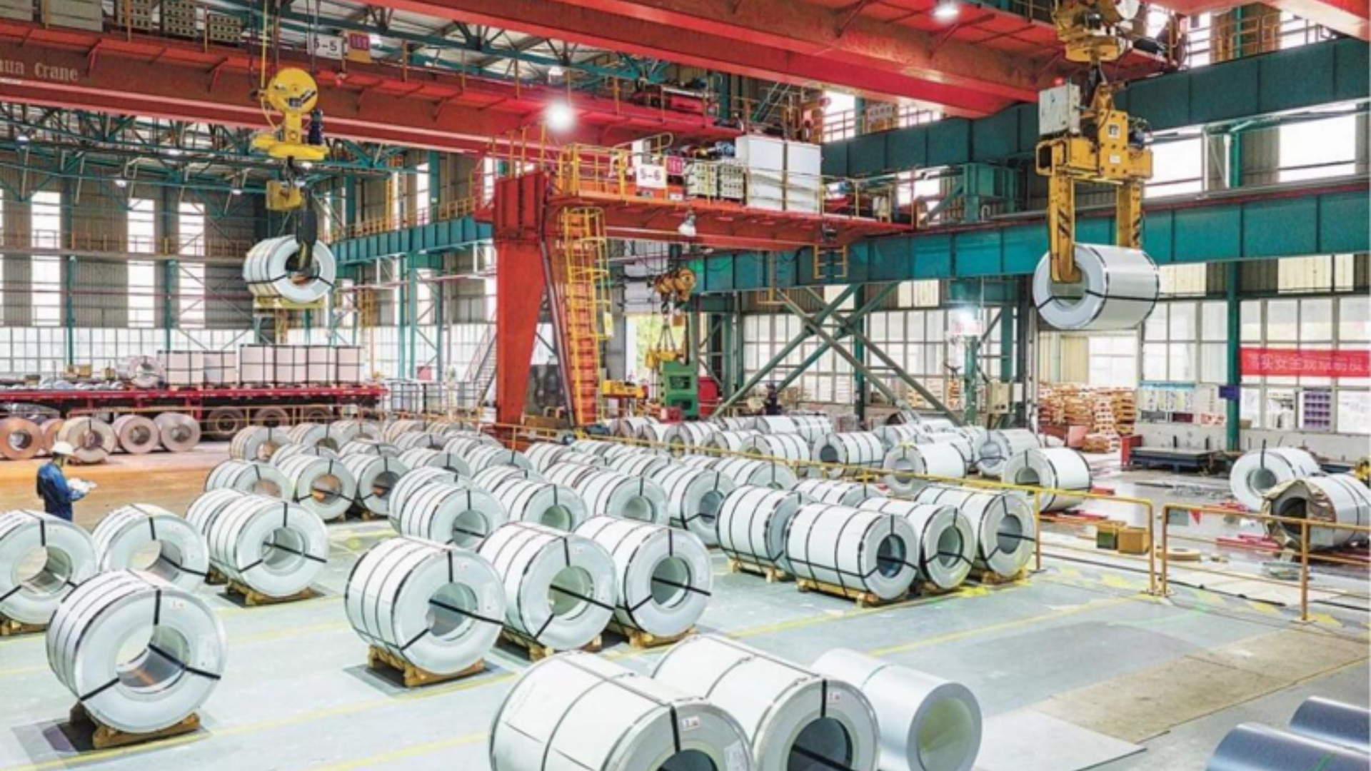 Massive industrial factory warehouse storing and transporting newly manufactured high-performance rolled steel coils.
