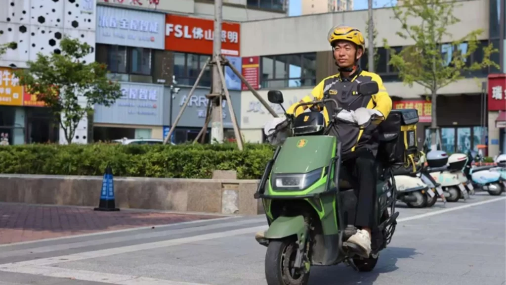 Delivery rider Chen Yiwen riding his electric scooter down a city street in east China.