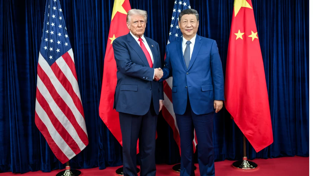 特朗普与习近平握手合影，背景为中美两国国旗。