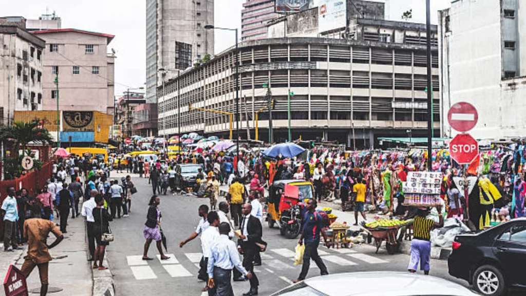 A busy city street where reliable infrastructure makes daily life feel dignified and less exhausting.
