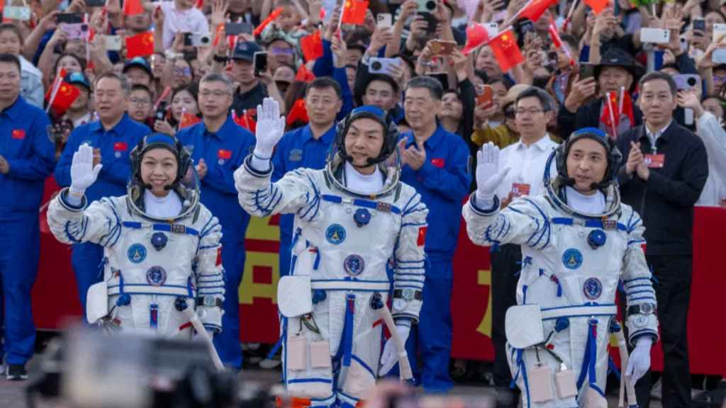 Three astronauts wave during the Shenzhou-23 send-off ceremony
