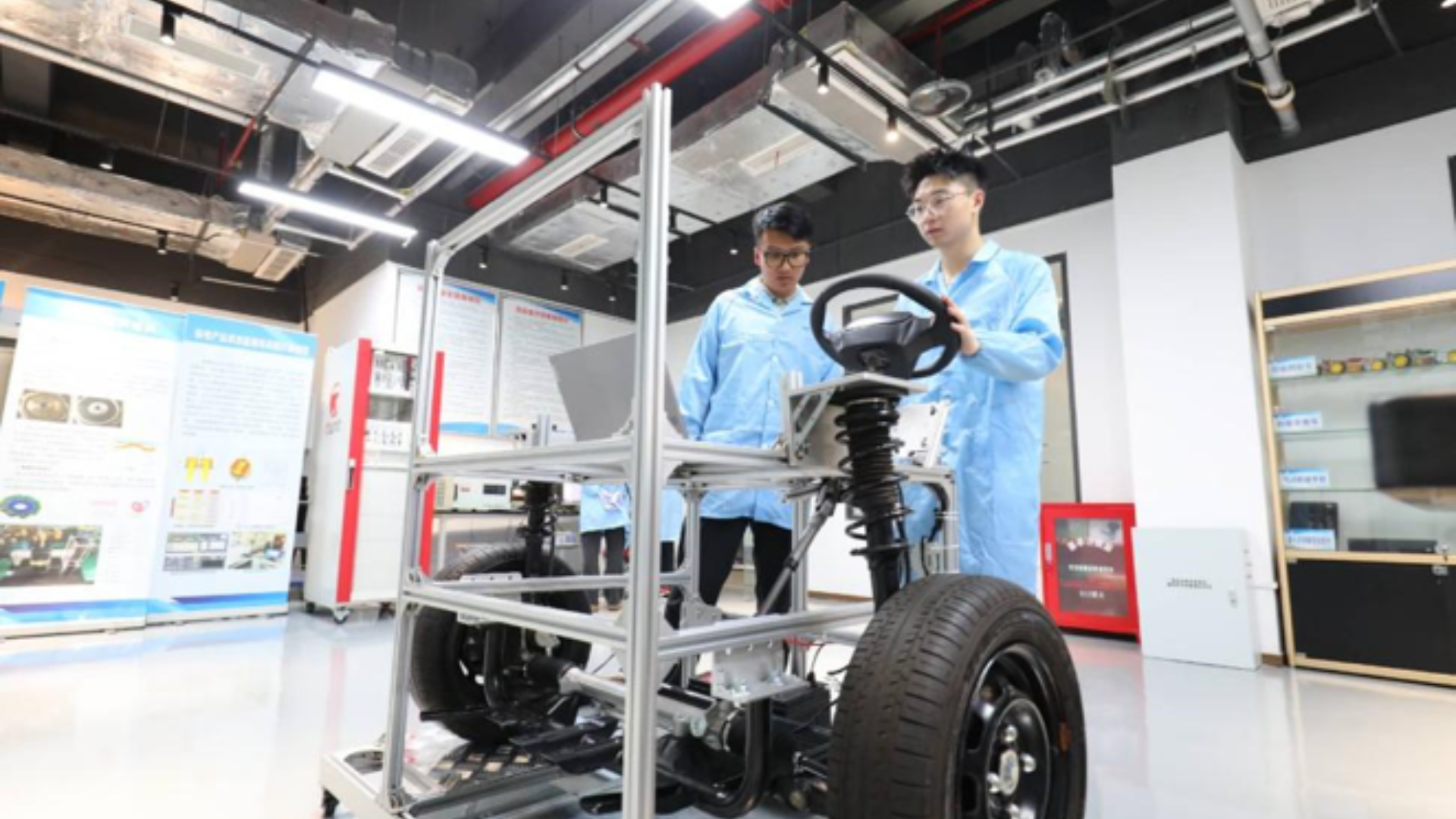 Young engineers test new energy vehicle technology at advanced automotive research laboratory.