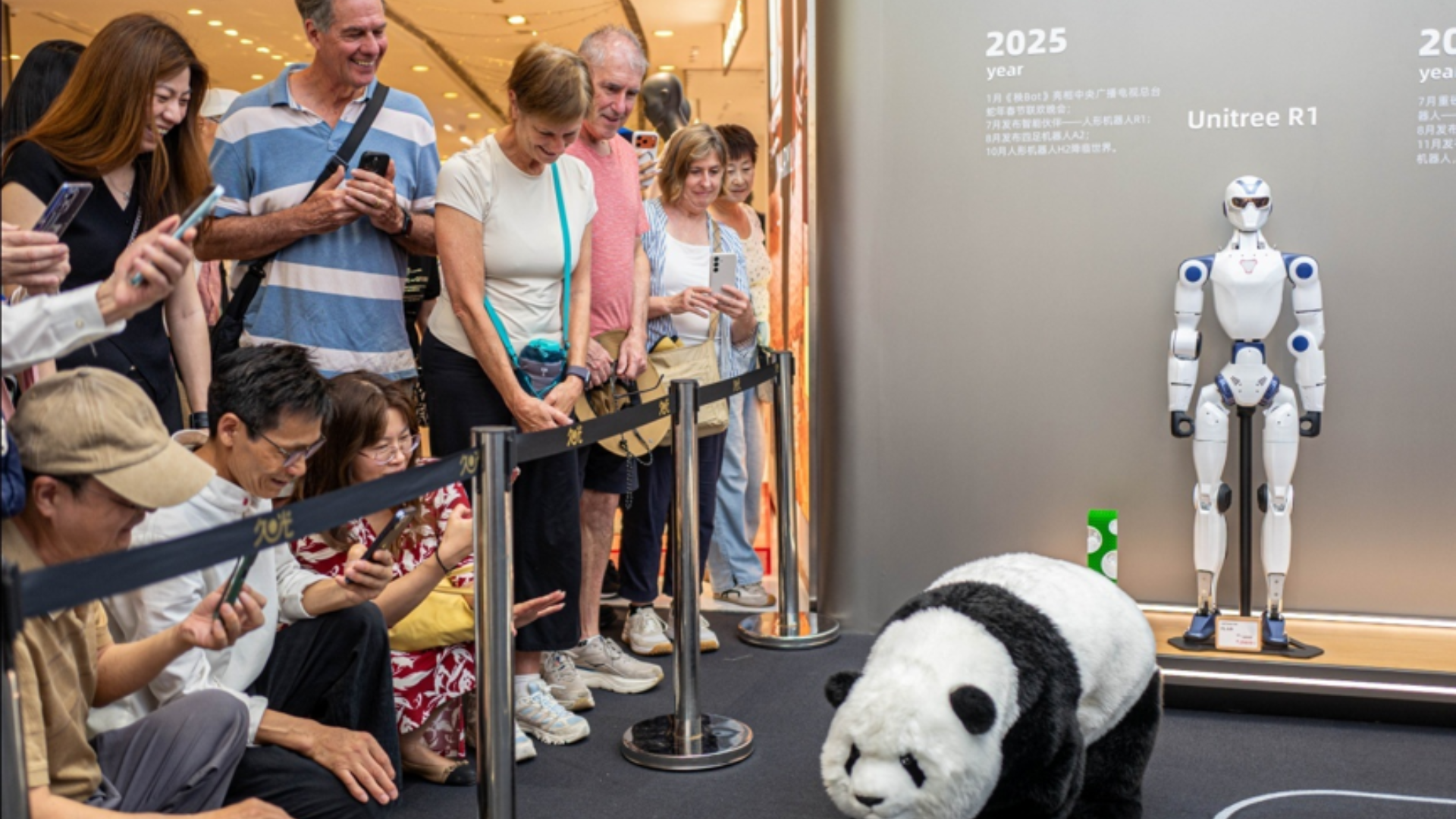 Tourists watching a panda-costumed robot dog at a Unitree experience center in Shanghai.