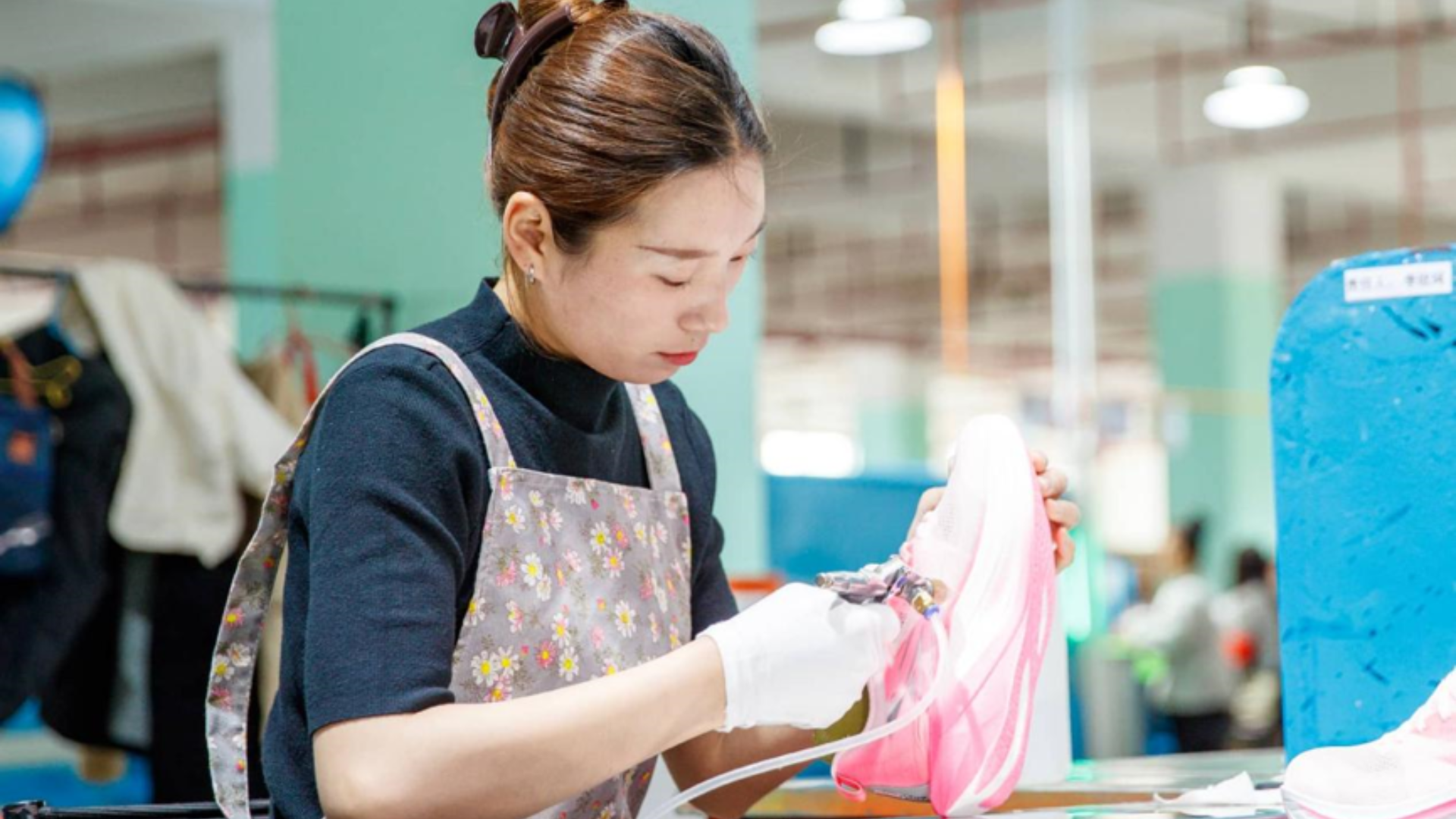 Factory worker crafting Chinese running shoes amid booming global cross-border e-commerce growth.