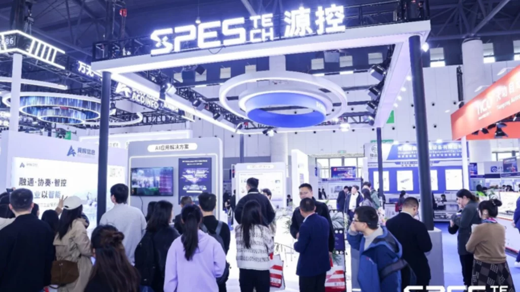 A brightly lit, bustling exhibition booth for Spes Tech at a busy technology trade show.