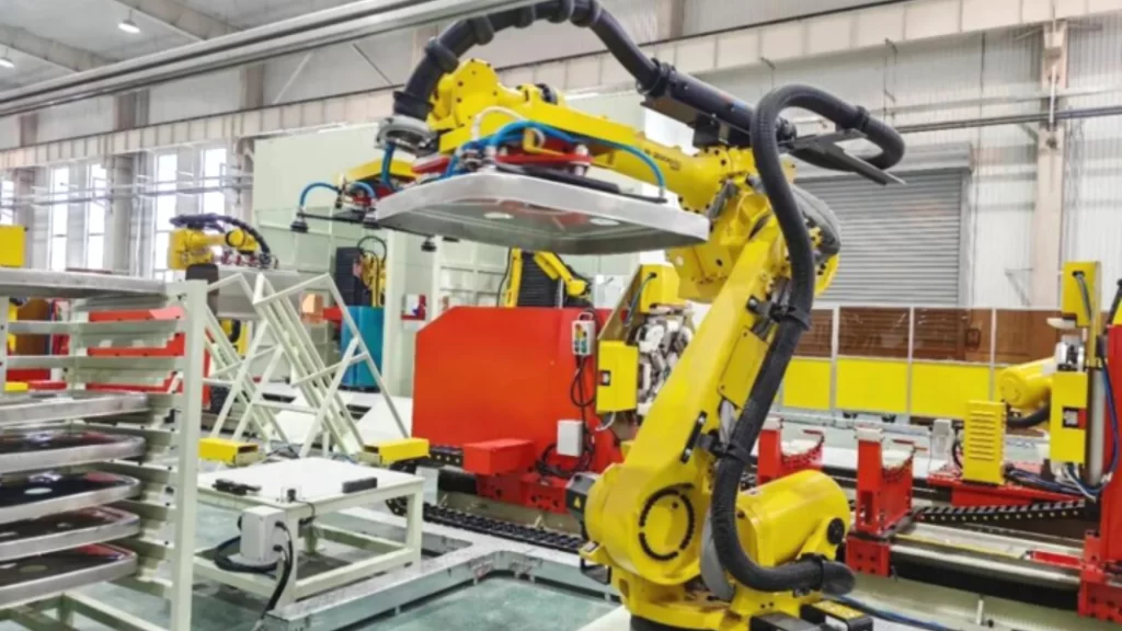 Yellow intelligent robotic arms operating inside a shared manufacturing factory.