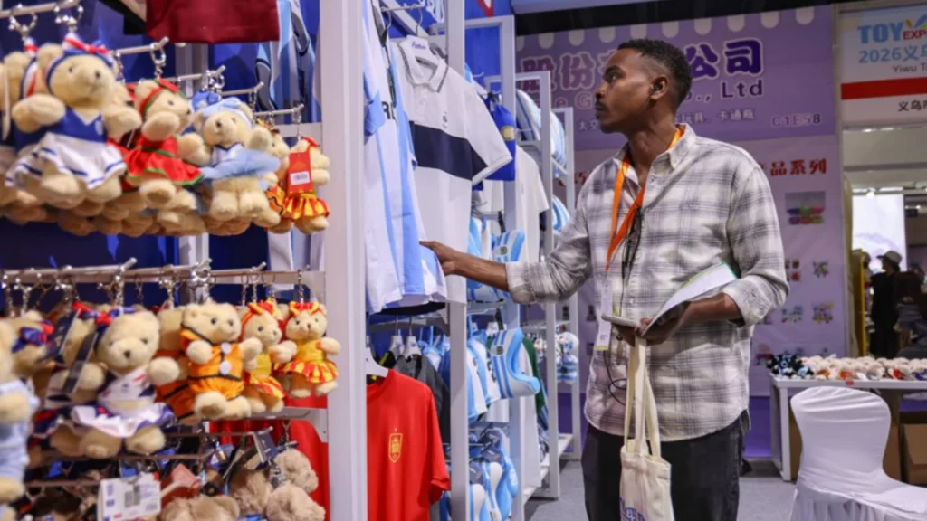 A businessman browse World Cup merchandise in Yiwu, shifting from price competition to innovation.
