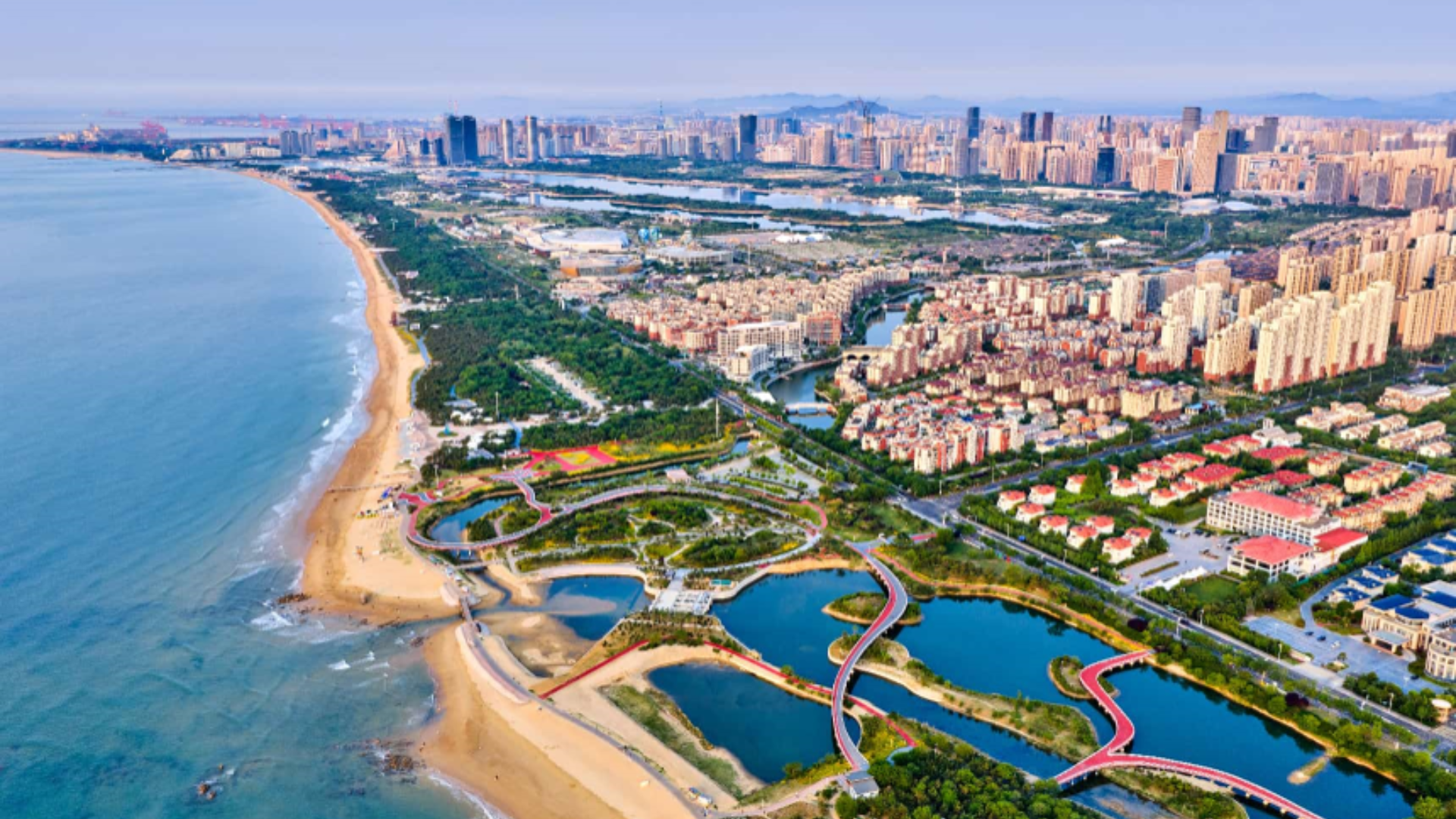 Aerial view of Rizhao coastline showcasing marina, eco-restoration, tourism and clear coastal waters.