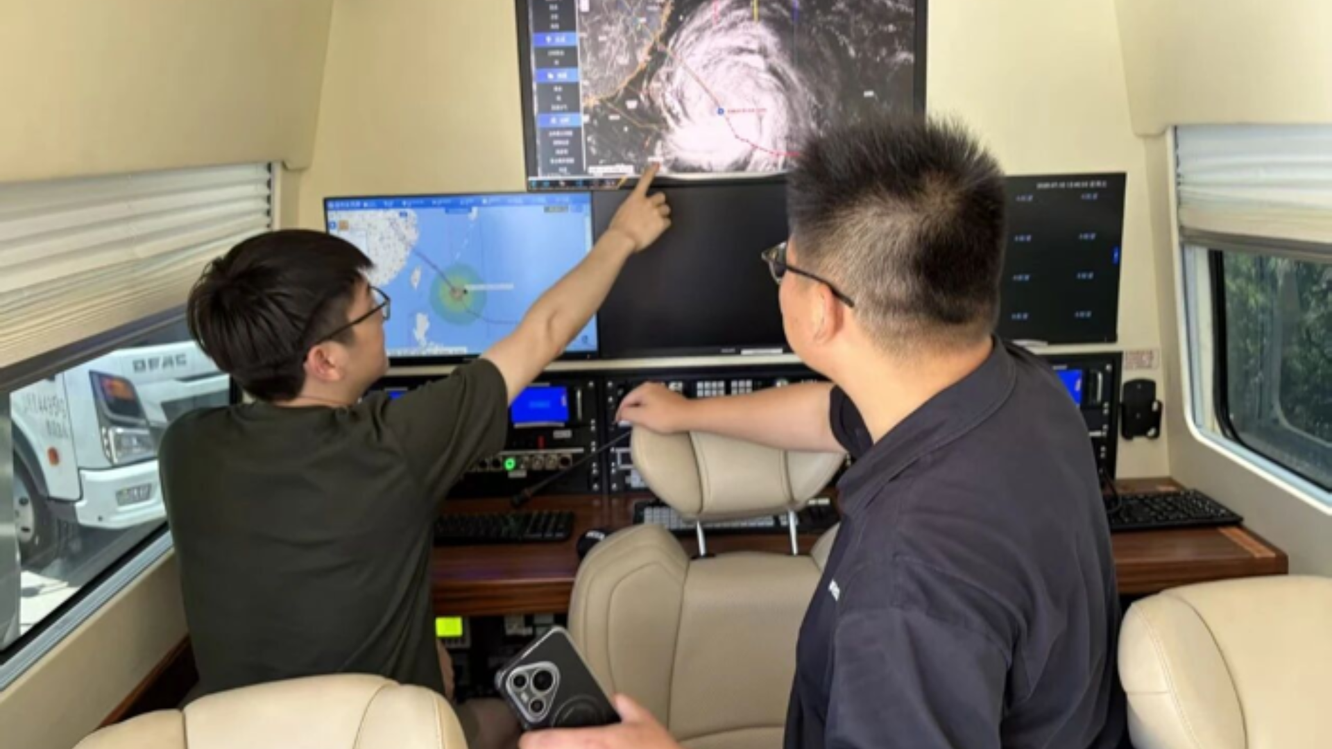 Meteorological technicians analyze Typhoon Bavi using smart technology for accurate forecasting and emergency response.