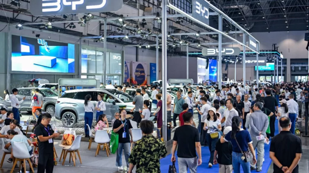 Visitors explore new energy vehicles at Hainan International Auto Show promoting green transportation transition.