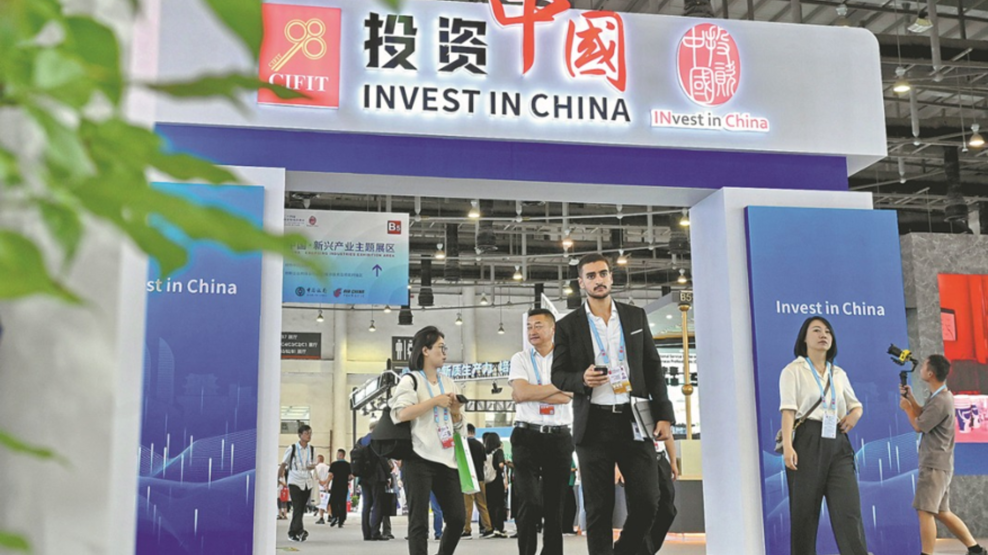 Attendees walk past the "Invest in China" pavilion showcasing the country's foreign investment efforts.