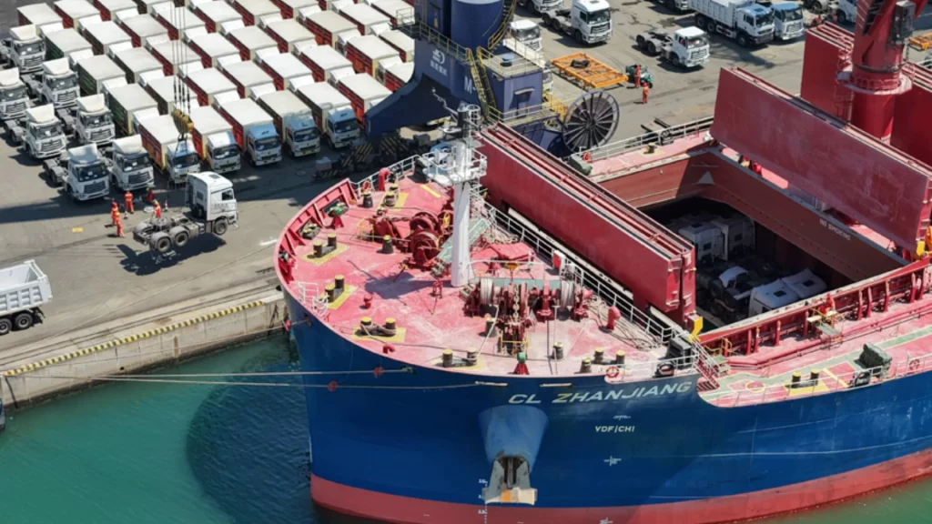 Export trucks loaded onto cargo vessel, supporting Belt and Road trade and global connectivity.
