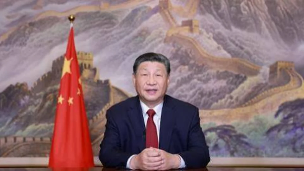 Chinese President Xi Jinping delivers a formal address in front of the Chinese flag.