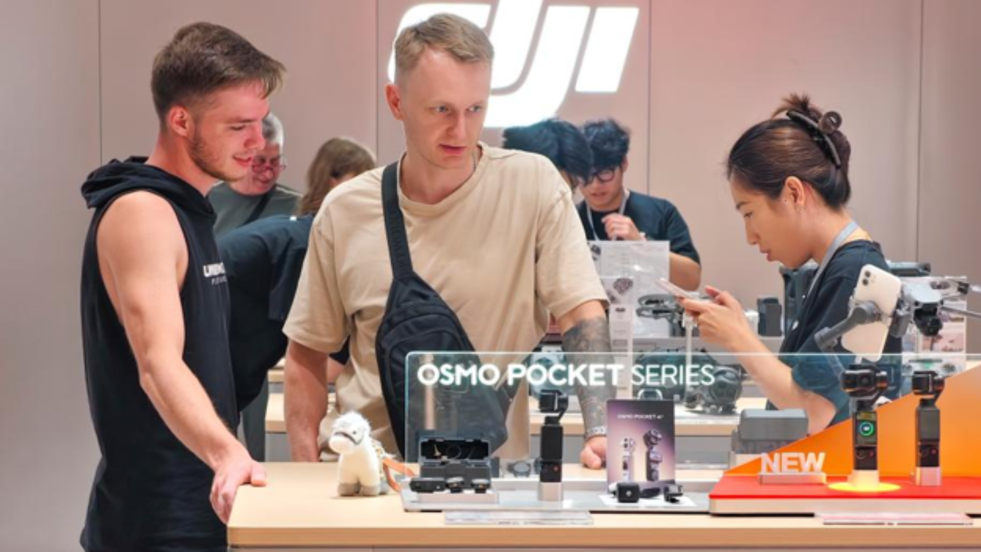Foreign tourists learn about a gimbal camera at a DJI store in Shanghai.