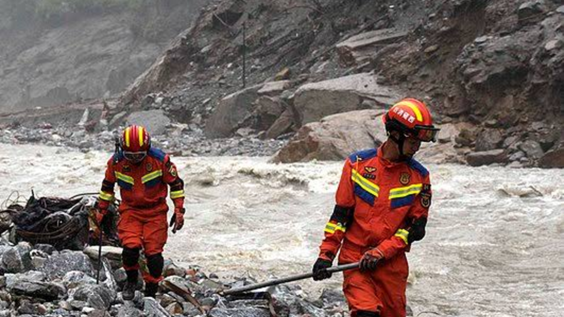 Chinese rescue personnel navigate rocky riverbed terrain following a severe mudslide in Gyirong County.