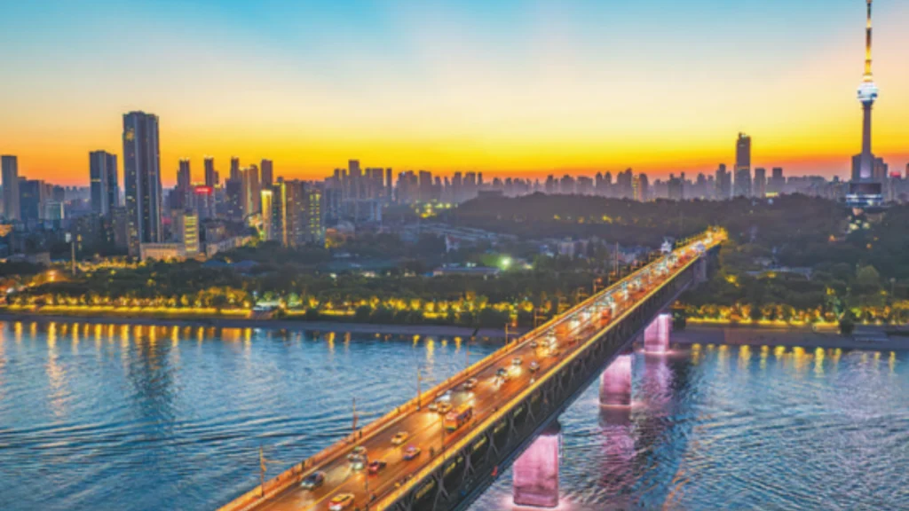 Wuhan Yangtze River Bridge illuminated at sunset after a green smart lighting upgrade.